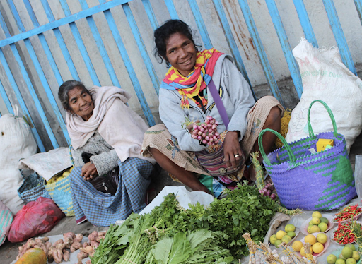 Two women sit at a market in Timor-Leste.