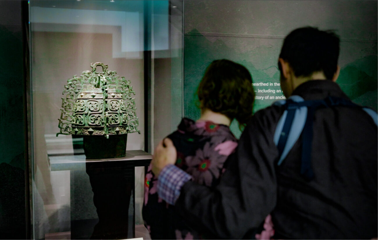 Young family looks at an ancient Chinese bronze artefact at Western Australia Museum exhibition.