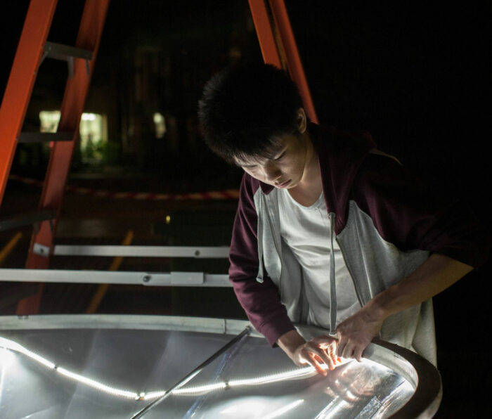 Team member from creative technology agency installs LED lights on the Vivid Fountain structure.