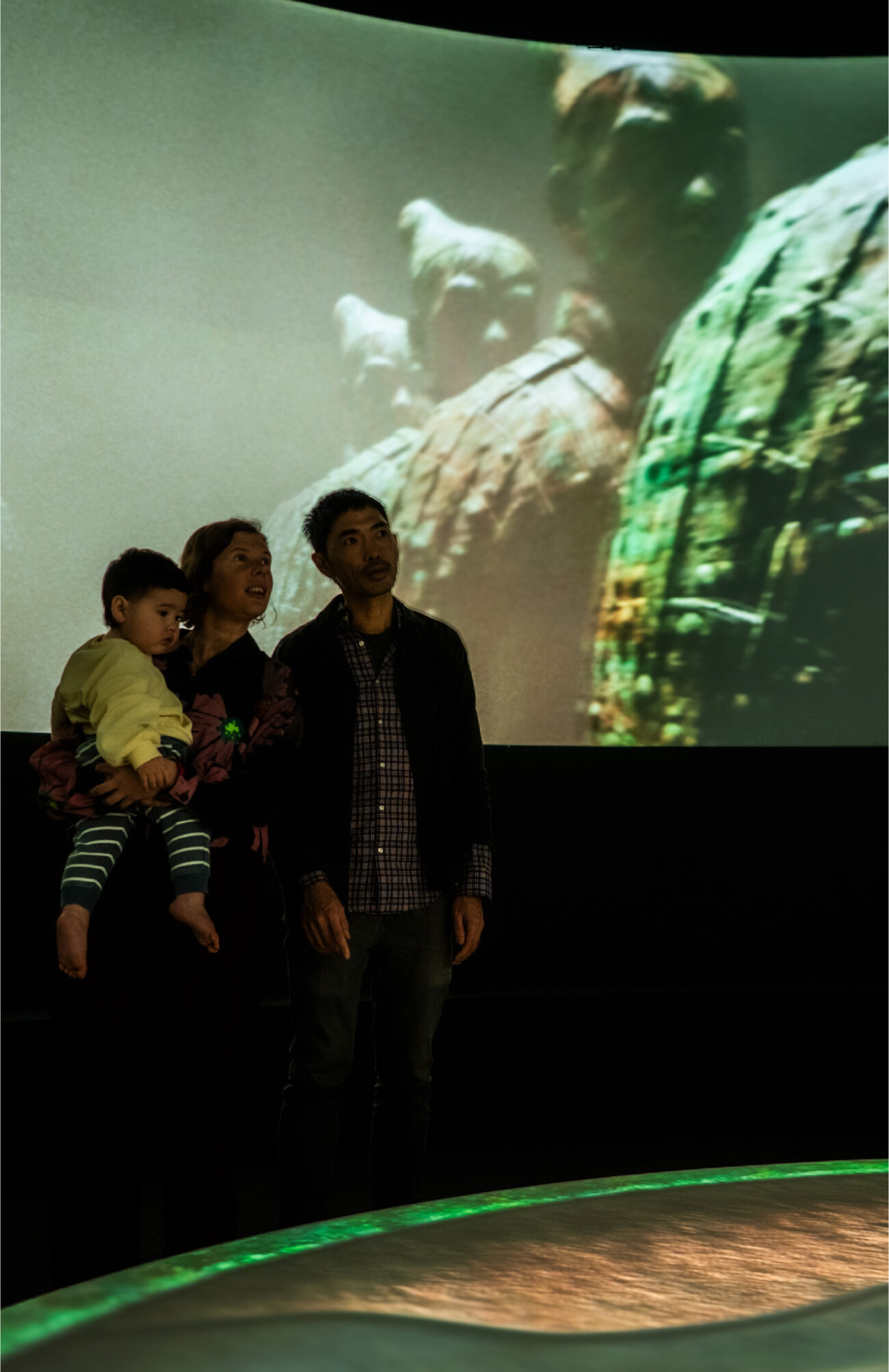 Young family stands immersed in S1T2's projection mapping experience for WA Museum's Terracotta Warriors exhibition.