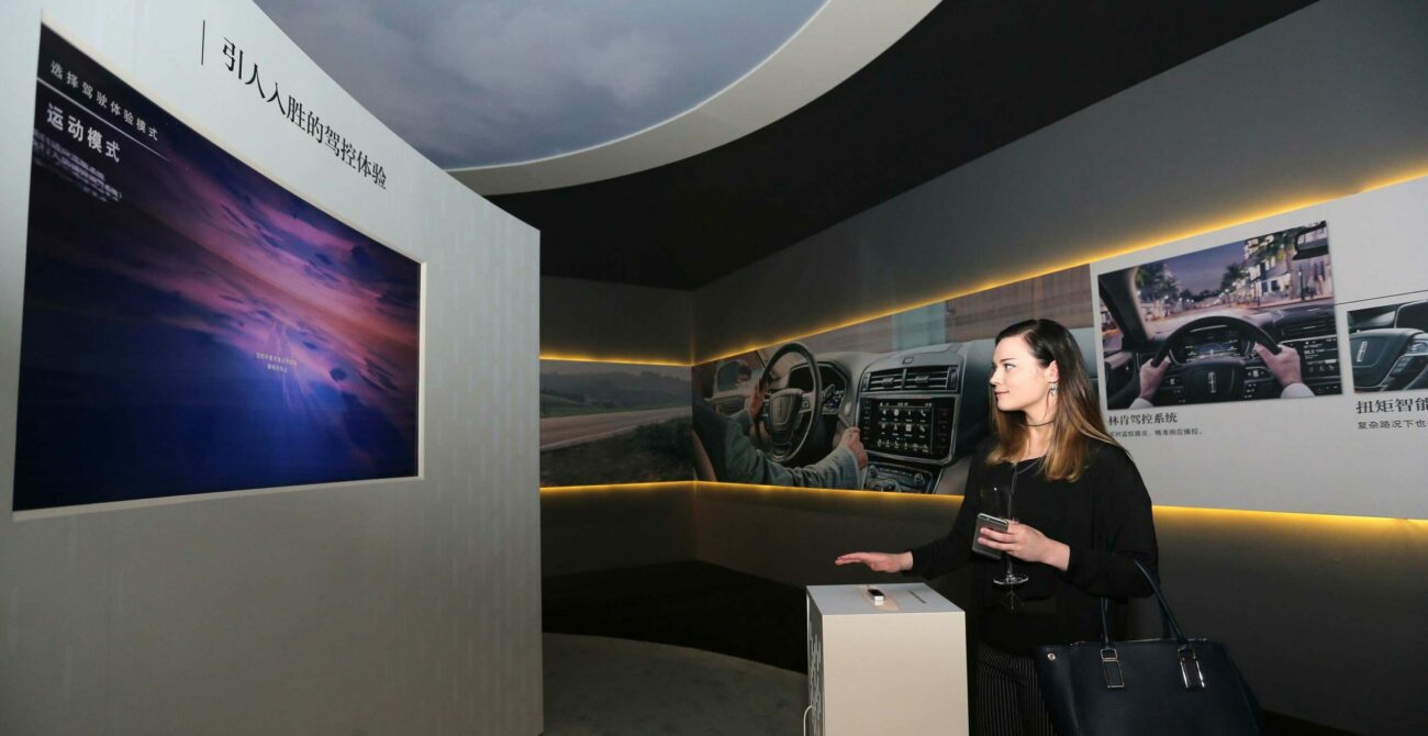 Woman at Auto Shanghai uses Leap Motion sensor to interact with experiential marketing activation.