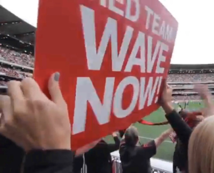 AFL fan holds ‘Red Team Wave Now’ sign at the Visa Wave and Win interactive halftime show.