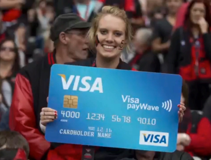 AFL fan holds large Visa card cash prize from Visa Wave and Win experiential marketing activation.