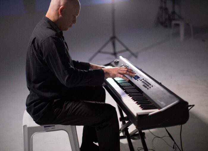 Composer Gavin Ahearn plays the piano during practice of the S1T2 Adobe Remix performance.