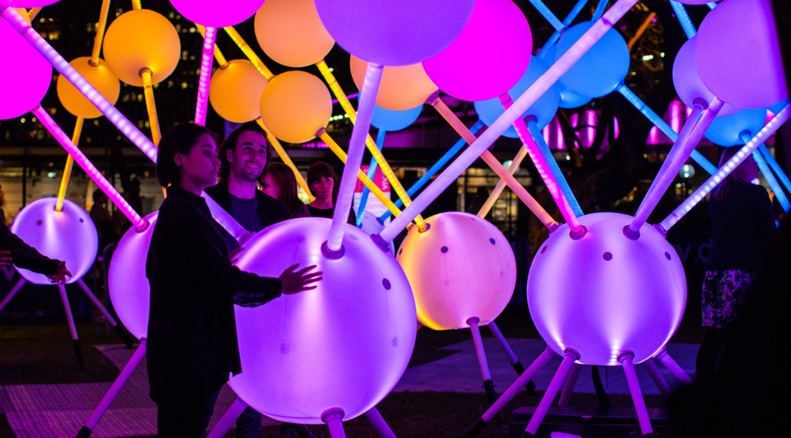 Two visitors interact with light installation Alzheimer’s Affinity at Sydney’s Vivid Festival.