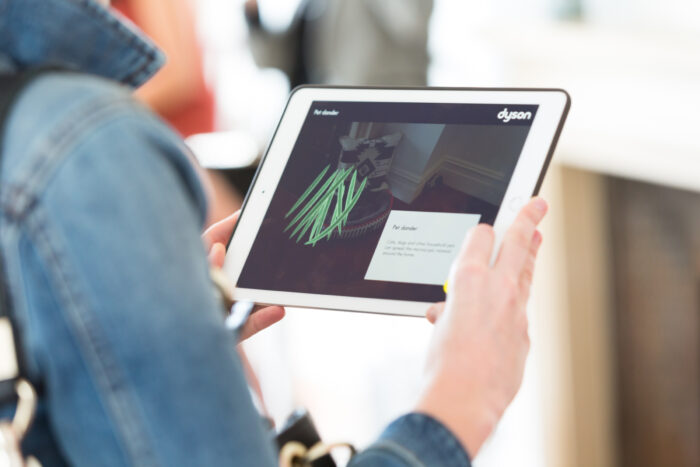 Woman interacts with bacteria data visualisation from the Dyson Tiny World AR digital marketing experience.