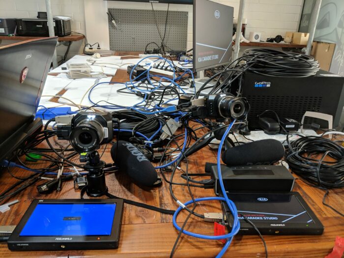 A mess of cables and technology on a table during production at creative technology agency.