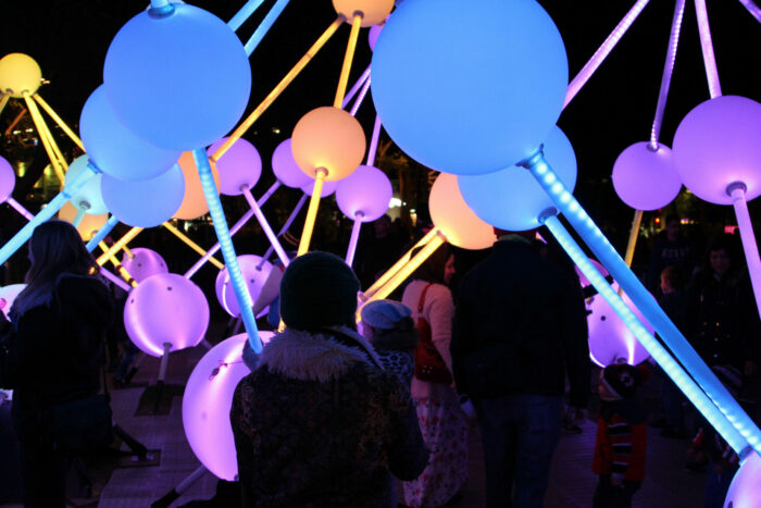 People interact with the touch-triggered light orbs from Alzheimer’s Affinity interactive artwork.