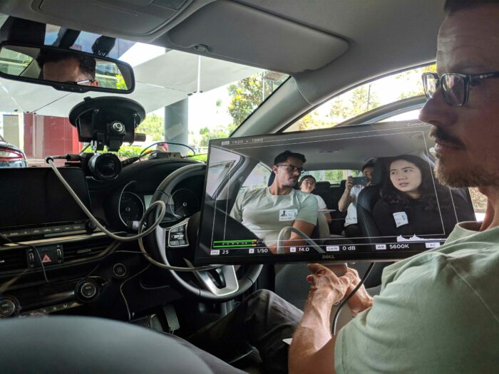 S1T2 team member holds up a screen displaying an in-camera capture during testing for Kia Caraoke Studio augmented reality experience.