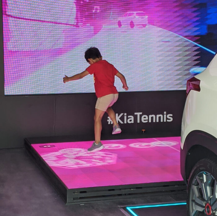 Small child jumps on the interactive LED dancefloor to interact with Kia Beat the Beat experiential marketing.