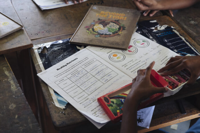 A Fijian school child uses crayons to complete a storybook activity as part of the Beyond the Stars health education program