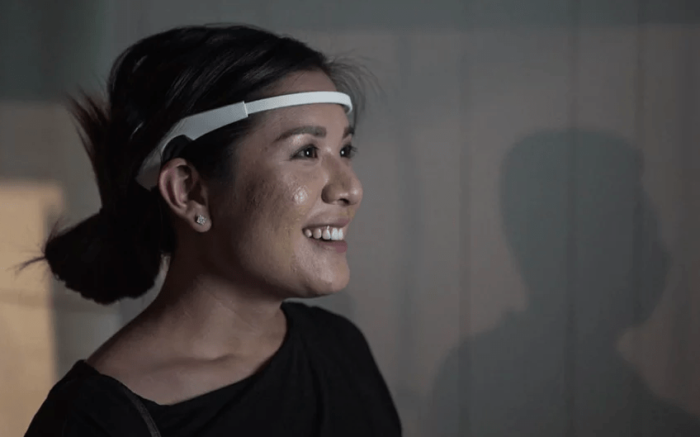 Woman wears white EEG headset to interact with Trent Brooks’ interactive artwork Arcs at Fables From The Threshold.