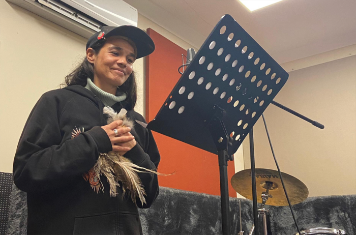 First Nations consultant Yaraan Couzens Bundle stands in a recording studio during development of the spoken word narration for Tyama immersive museum Melbourne.