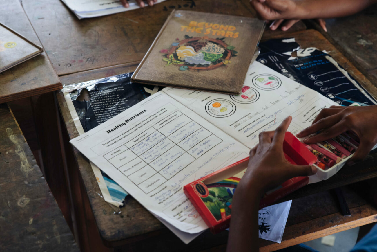 A Fijian child completes a chapter in the Beyond the Stars activity book.