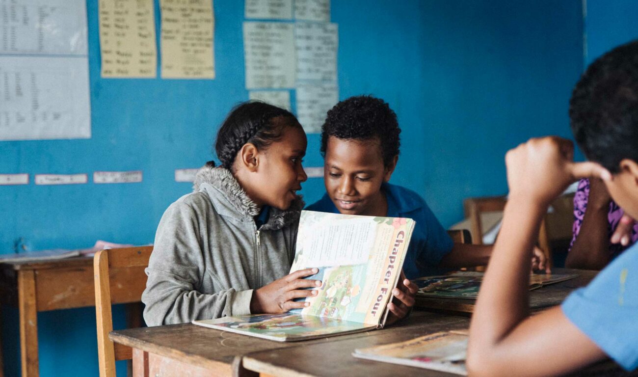 Two Fijian students read the Beyond the Stars educational storybook during class.