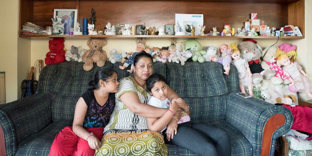 Family who used the Beyond the Stars educational pilot sits together in their home in Sigatoka, Fiji.