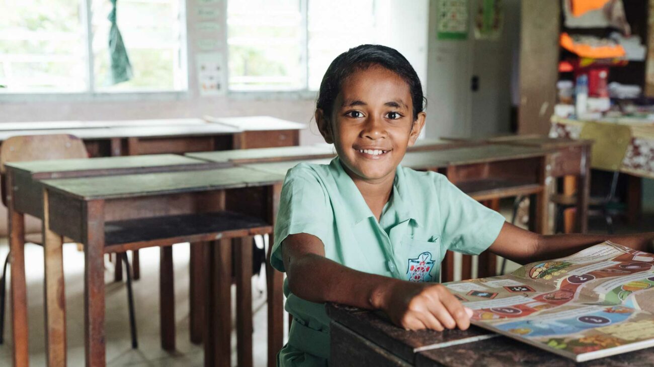 A Fijian student looks through a Beyond the Stars storybook in her classroom.