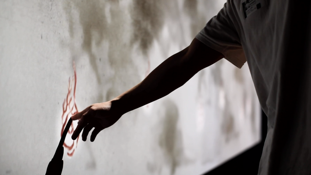 Man touches a flame animated interactive touch point made with conductive ink.