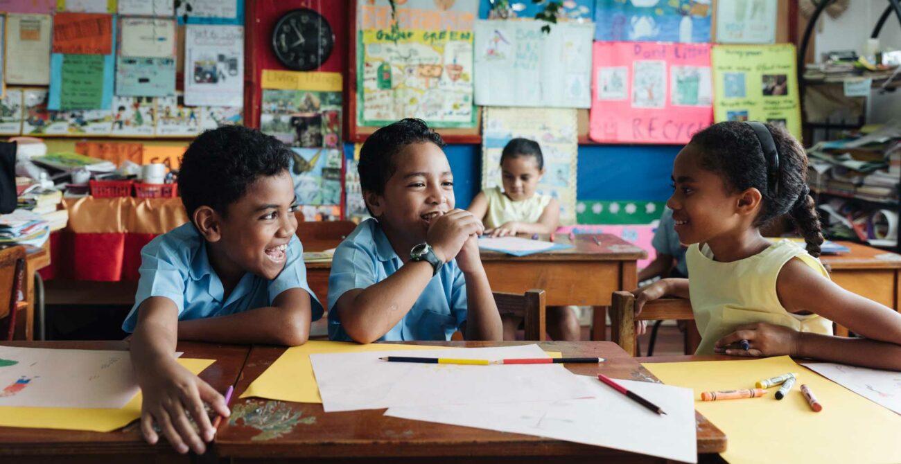 Three children play in a classroom in Fiji.