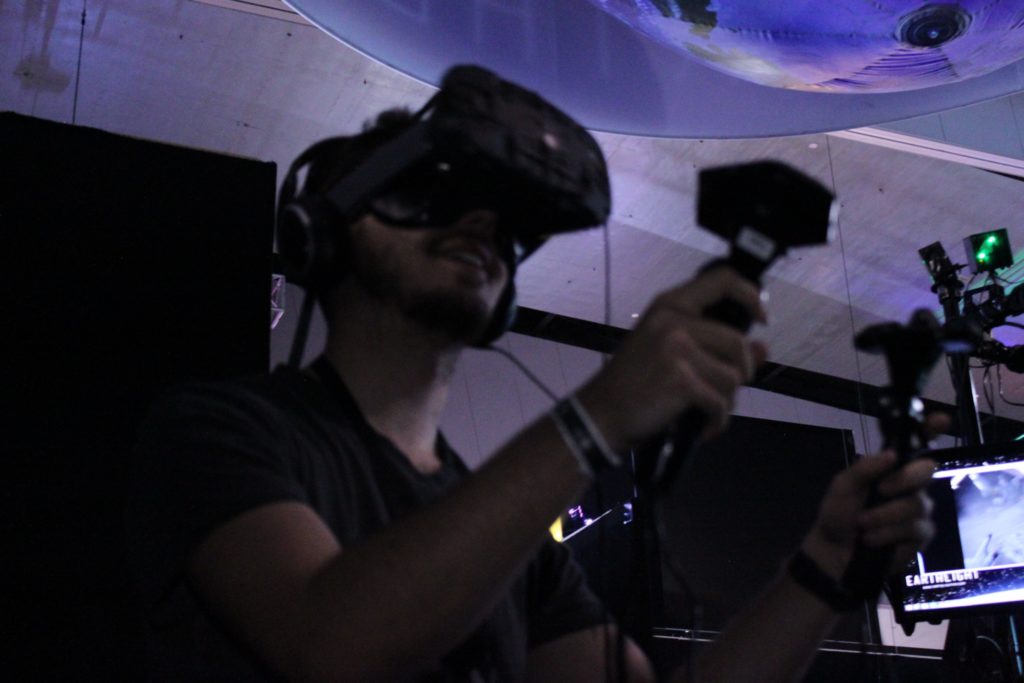 User wearing Virtual Reality goggles with Vive Controller.