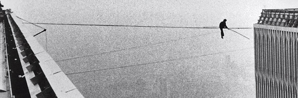 Black and white photograph of man on a tightrope.