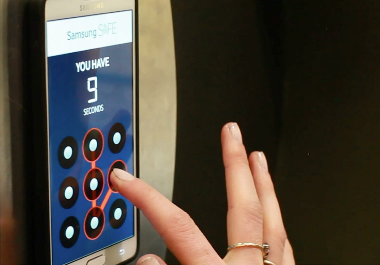 Woman&#039;s hand puts a combination into the Samsung Safe smartphone interface.